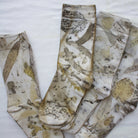 Botanical Eucalypt Socks - Melo Handmades - Botanical socks hand-dyed with eucalyptus leaves in soft gold, brown, and green tones, laid flat on white linen.