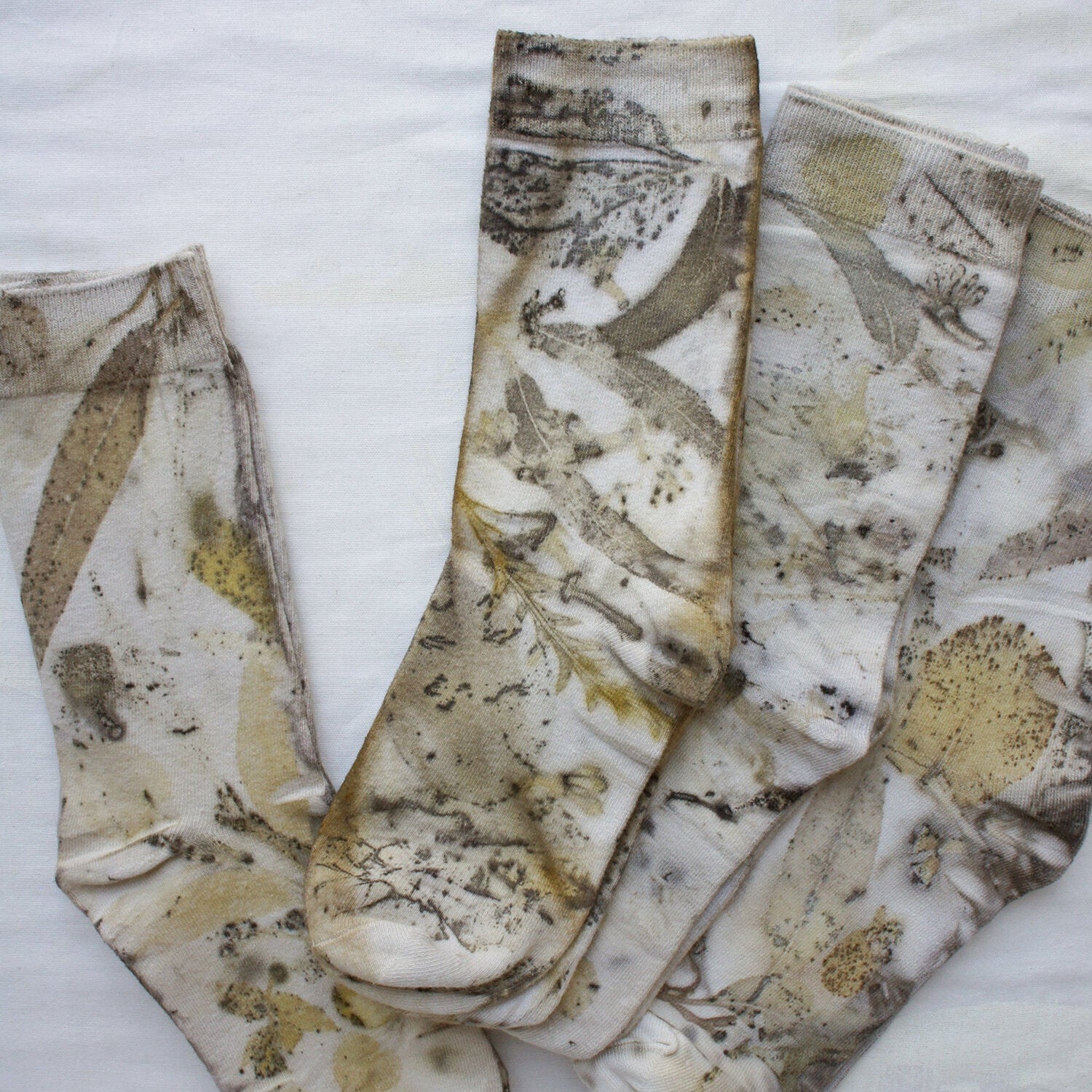 Botanical Eucalypt Socks - Melo Handmades - Botanical socks hand-dyed with eucalyptus leaves in soft gold, brown, and green tones, laid flat on white linen.