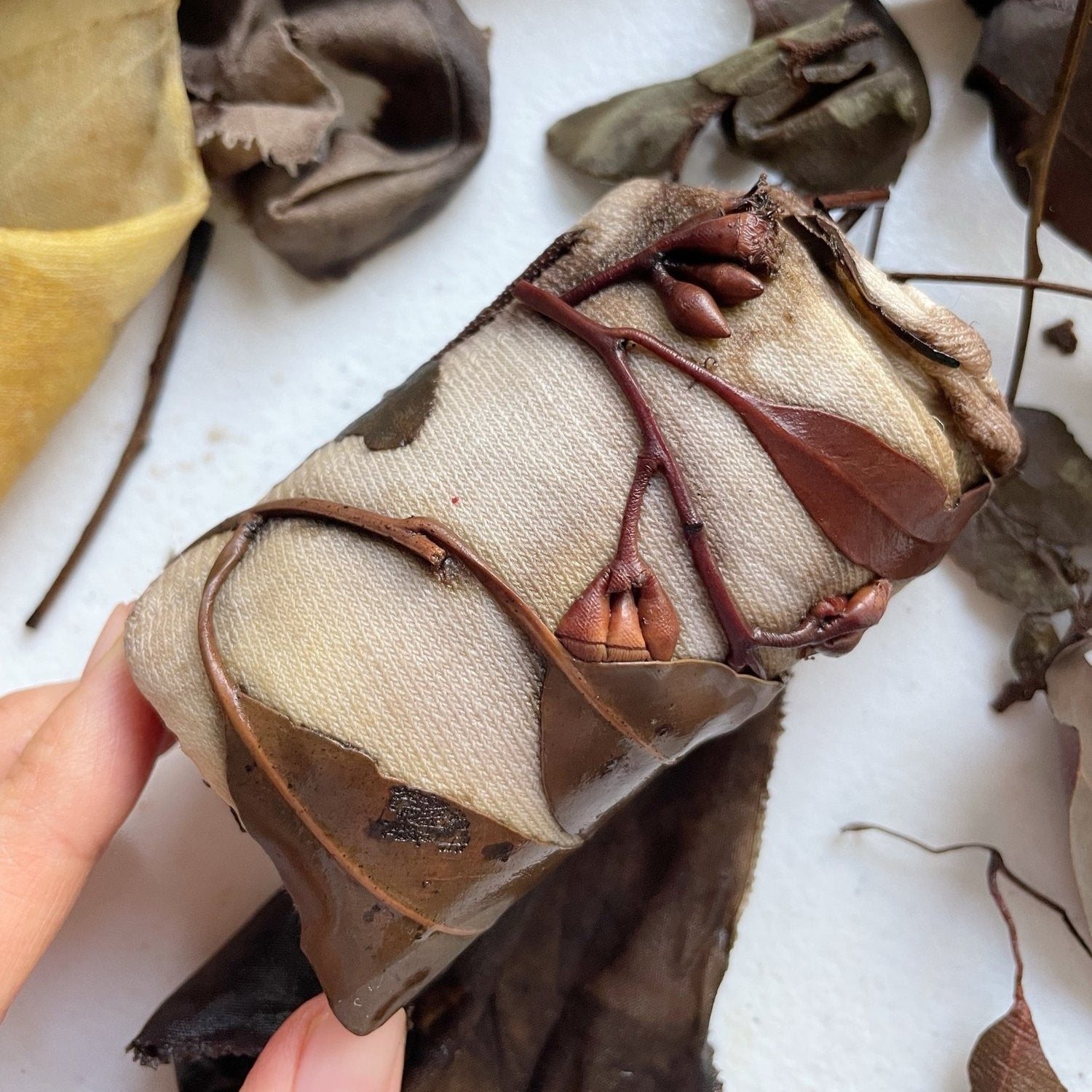 Botanical Eucalypt Socks - Melo Handmades - Botanical socks hand-dyed with eucalyptus leaves in soft gold, brown, and green tones, laid flat on white linen.